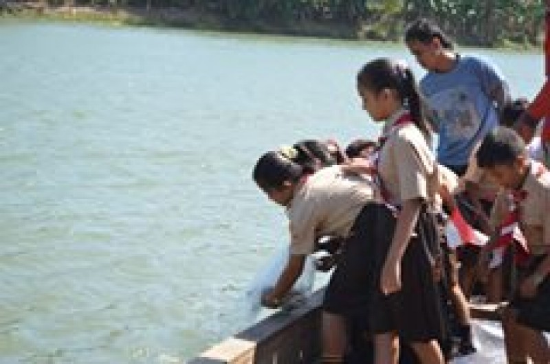 Siswa - siswi sekolah ikut menabur ikan 
